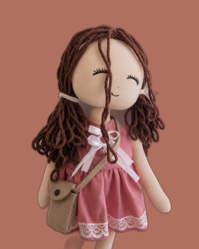 Brown-haired doll in a rose dress with lace hem and a little crossbody bag
